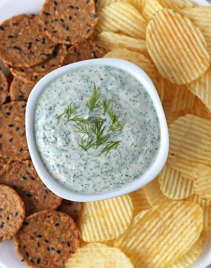 Vega veggie dip in a bowl, crackers and chips surround the dip.