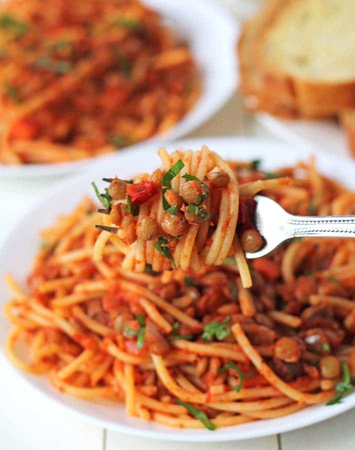 Green lentil pasta on a fork.