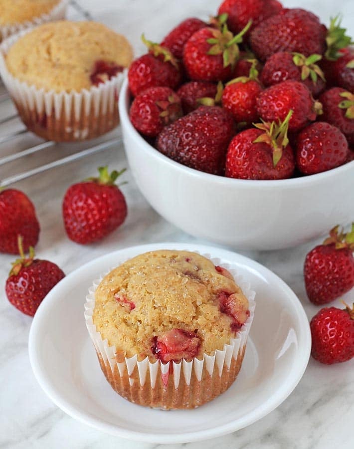 Vegan gluten free strawberry muffin on a small white plate.