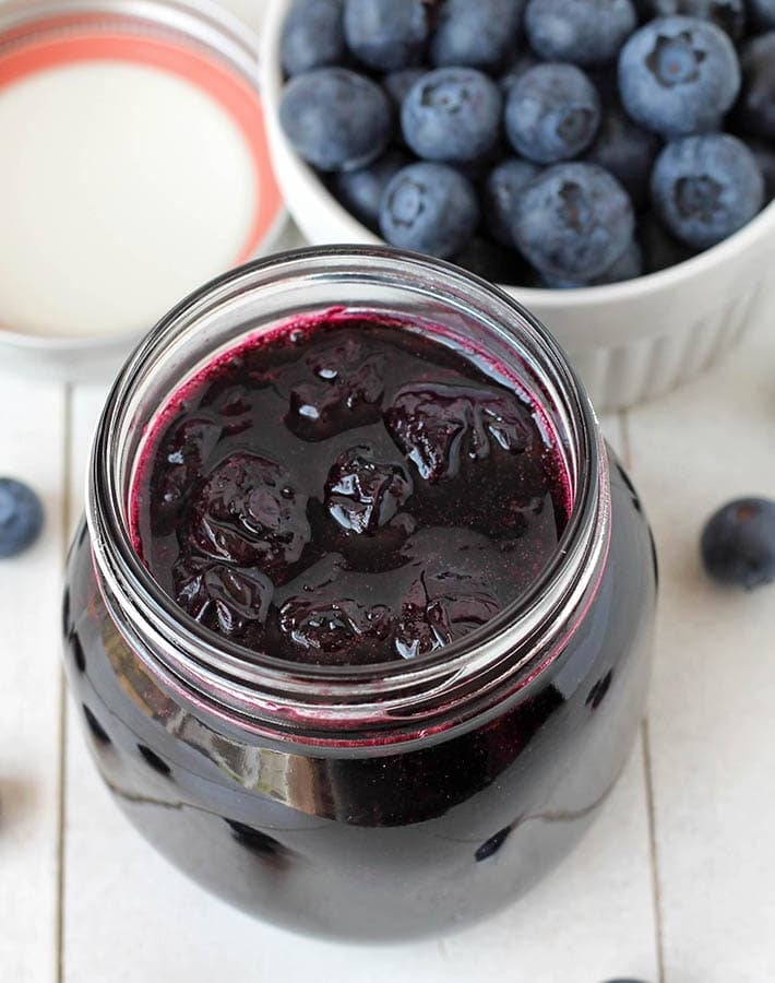 Overhead shot of an open jar of berry sauce.