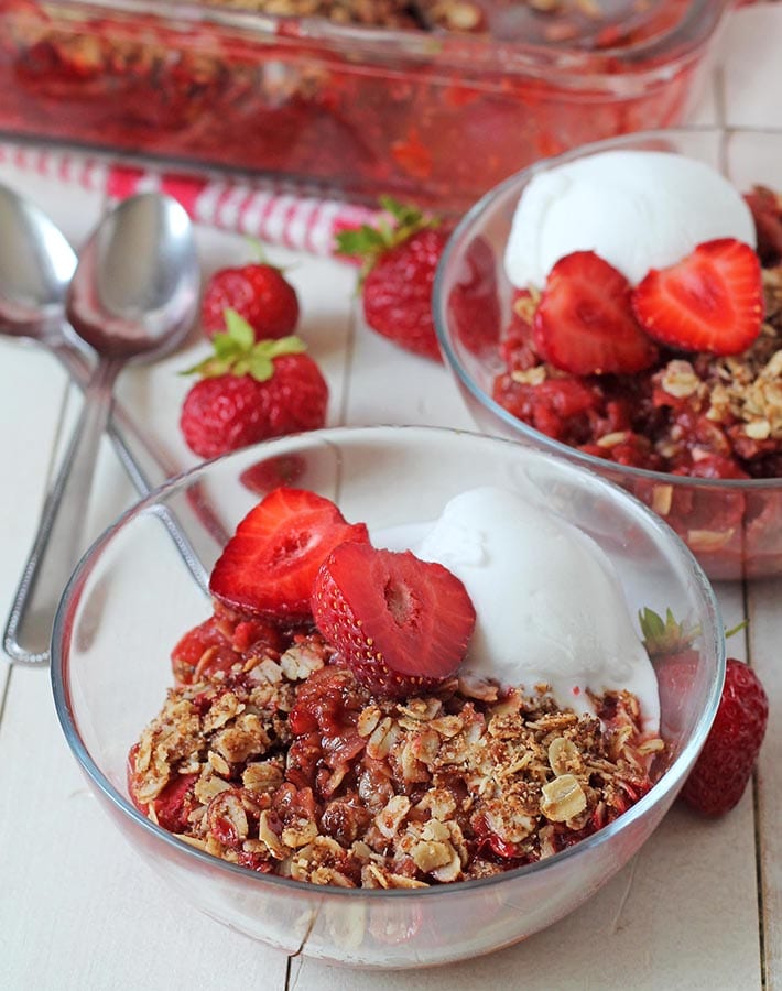 Gluten free strawberry rhubarb crumble recipe, freshly made, in two glass bowls.