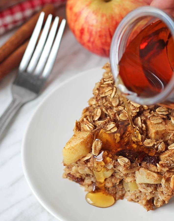 Maple syrup being poured onto a piece of vegan baked oatmeal.