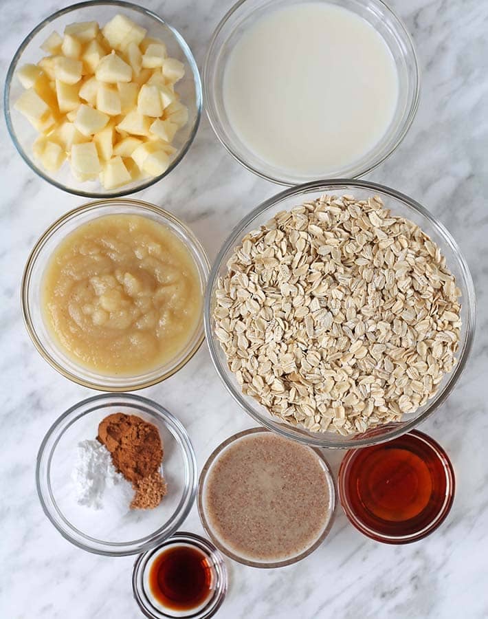 The ingredients for apple cinnamon baked oatmeal in separate glass bowls.