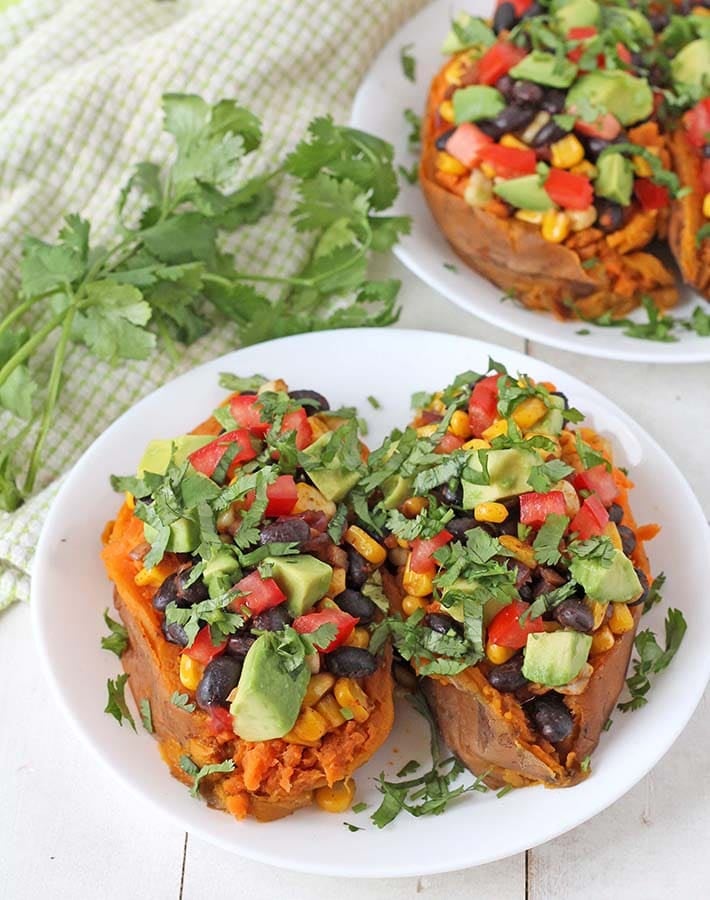 Loaded baked sweet potatoes on a white plate.