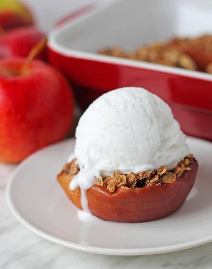 Baked apple dessert on a small plate, a scoop of ice cream is on top of the dessert.