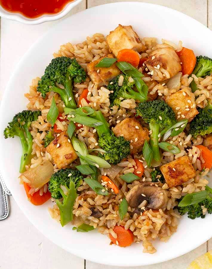 Overhead image of vegan fried brown rice with lots of veggies on a plate.