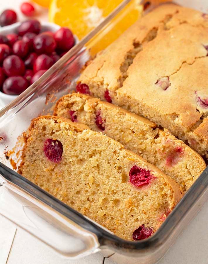 Slices of gluten free cranberry orange loaf in a glass baking dish.