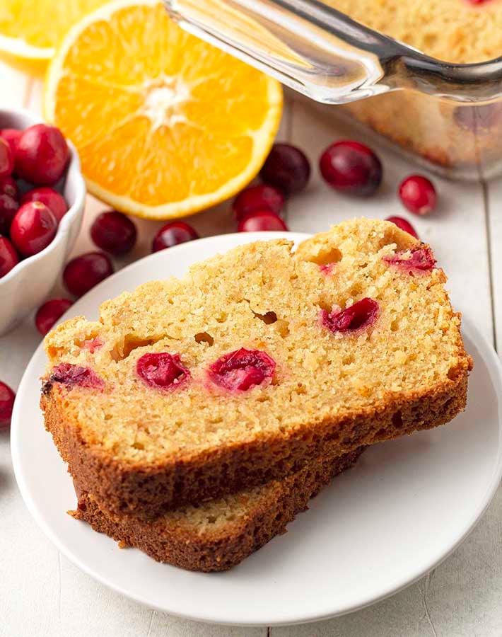 Two slices of cranberry orange bread on a white plate.