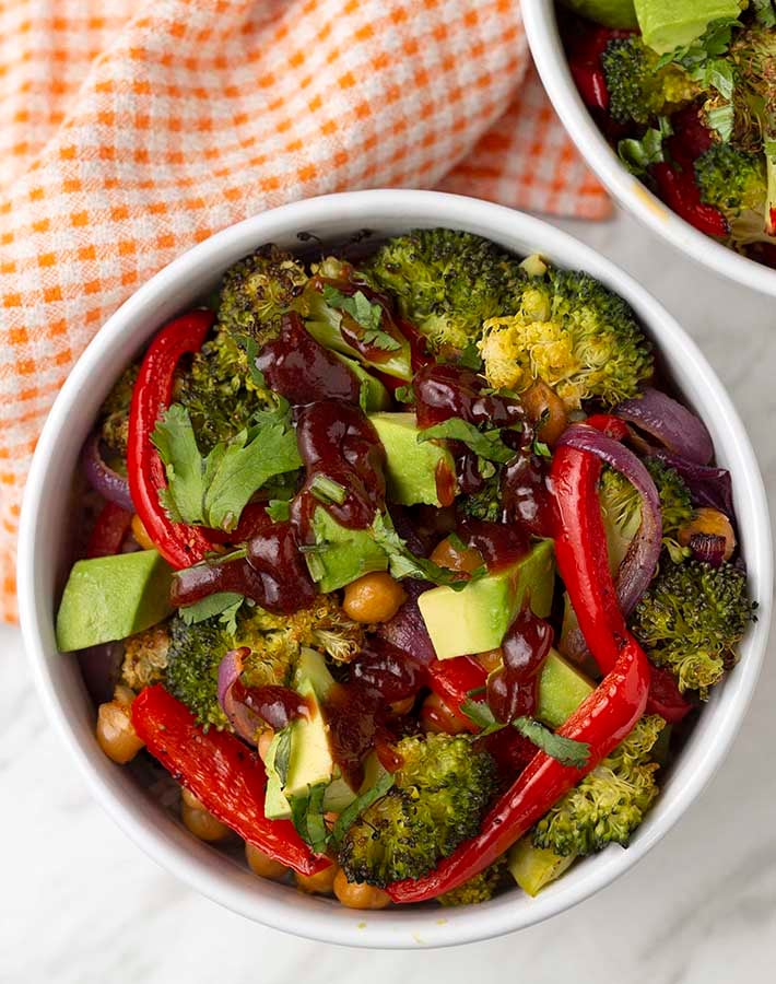 Overhead shot of a simple rice and roasted vegetable bowl with barbeque sauce drizzled on top.