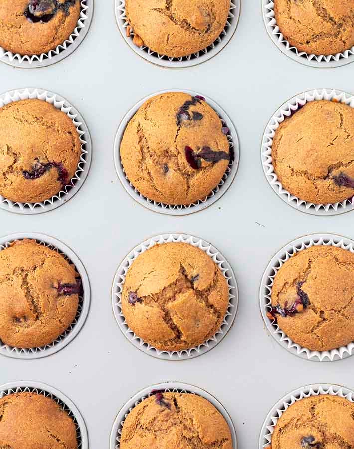 Overhead shot of gluten free blueberry banana muffins in a muffin pan fresh out of the oven.