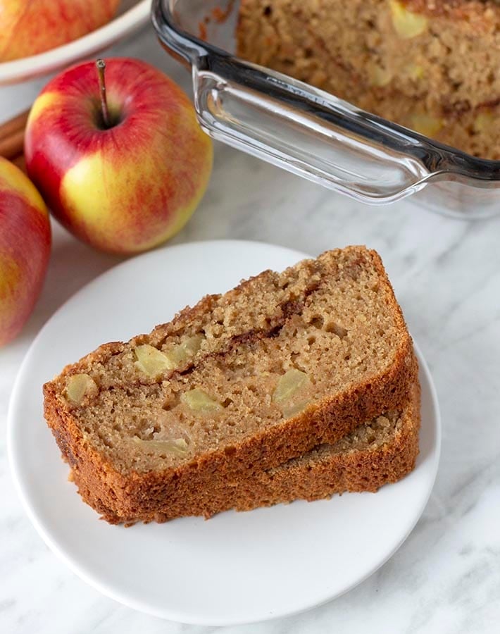 Two slices of gluten free apple cinnamon bread on a small white plate.