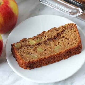 A slice of vegan applesauce bread on a small white plate.