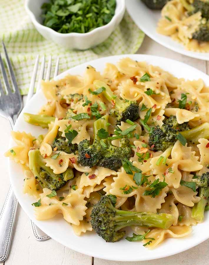 Close up shot of a plate of bow tie pasta with broccoli.