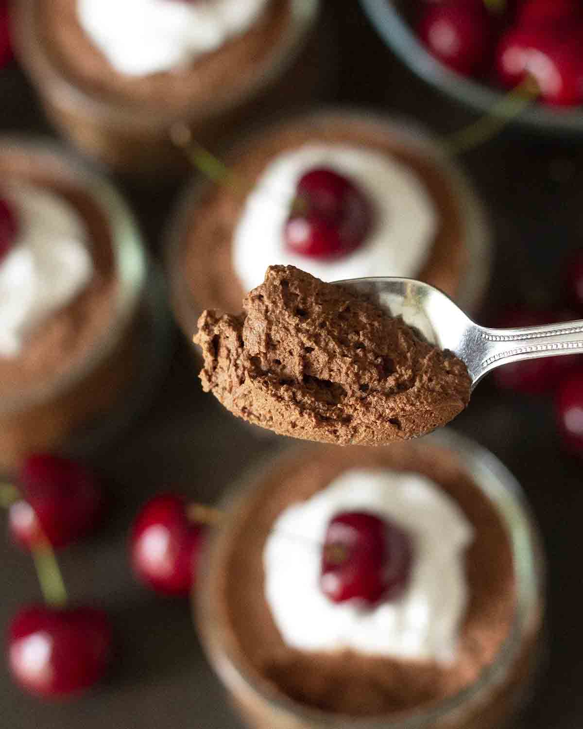 A close up shot of dairy-free chocolate mousse on a spoon to show the fluffy, bubbly texture.