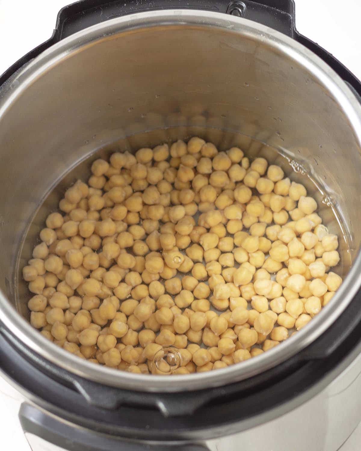 Overhead shot of chickpeas and water in an Instant Pot.