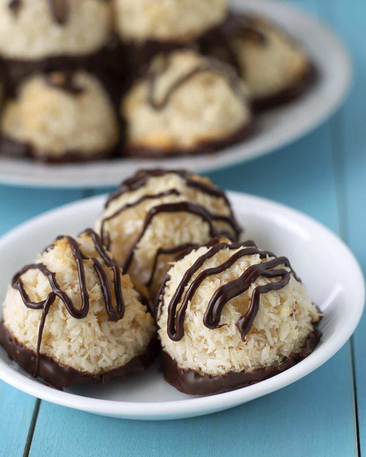 Three coconut macaroons sitting on a small white plate.