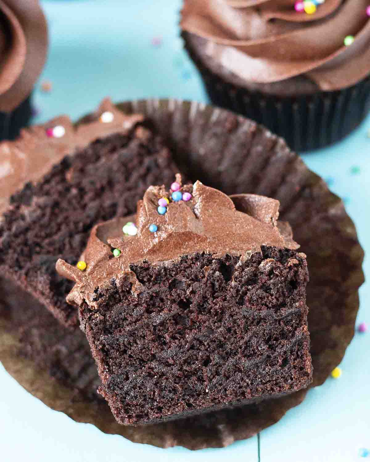 A gluten free chocolate cupcake split in two to show the fluffy texture inside.