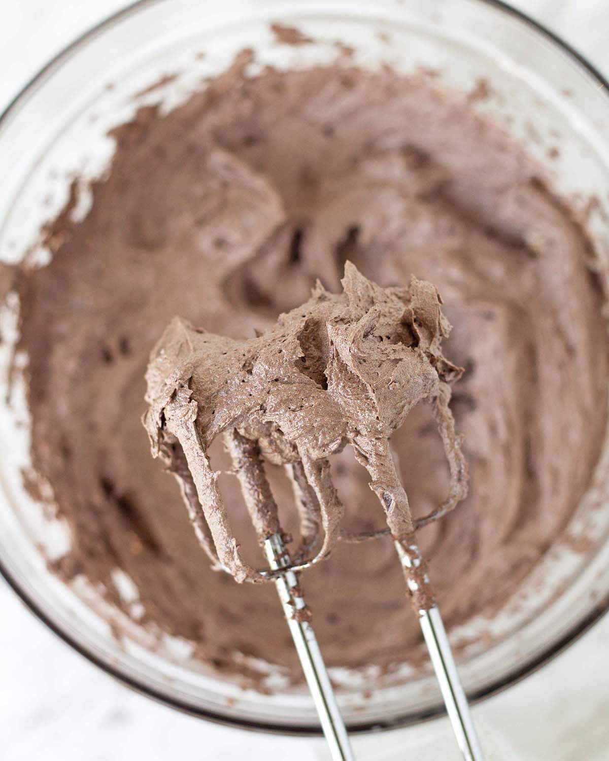 Vegan chocolate frosting on two electric mixer beaters.