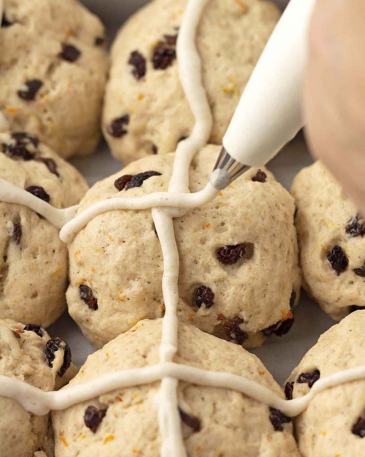 Image showing the flour crosses being piped onto gluten-free Easter cross buns.