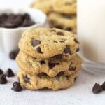 A close up shot showing a stack of three chocolate chip cookies.