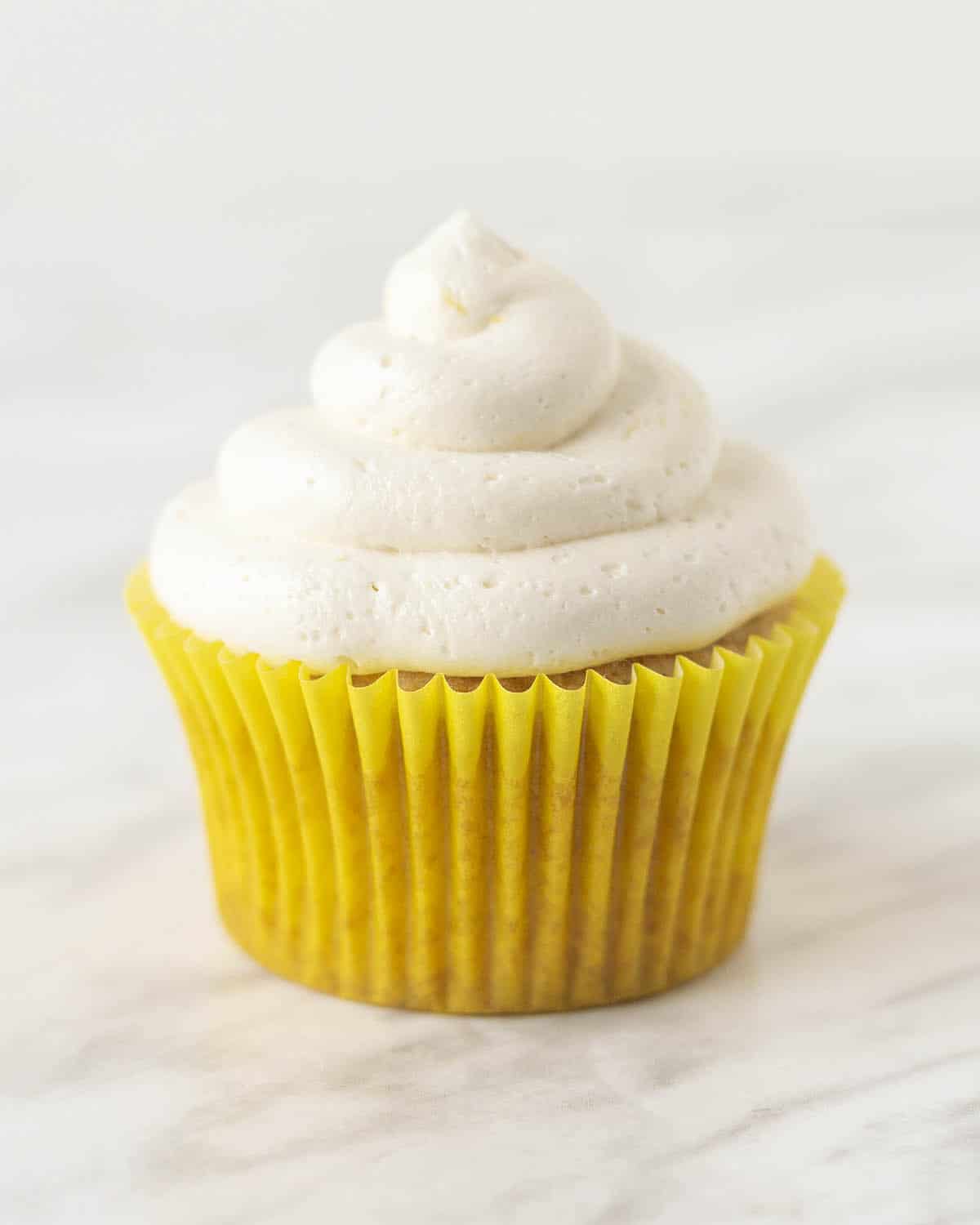 A lemon cupcake topped with dairy-free lemon buttercream.