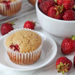 Vegan strawberry muffin on a small white plate.