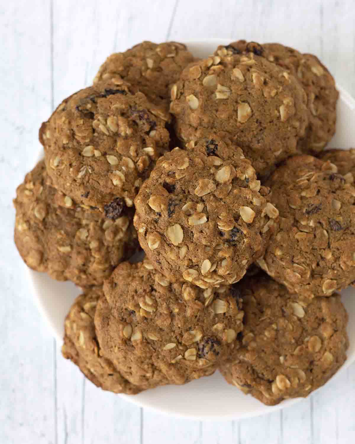 An overhead image showing a plate full of soft-baked vegan oatmeal raisin cookies.