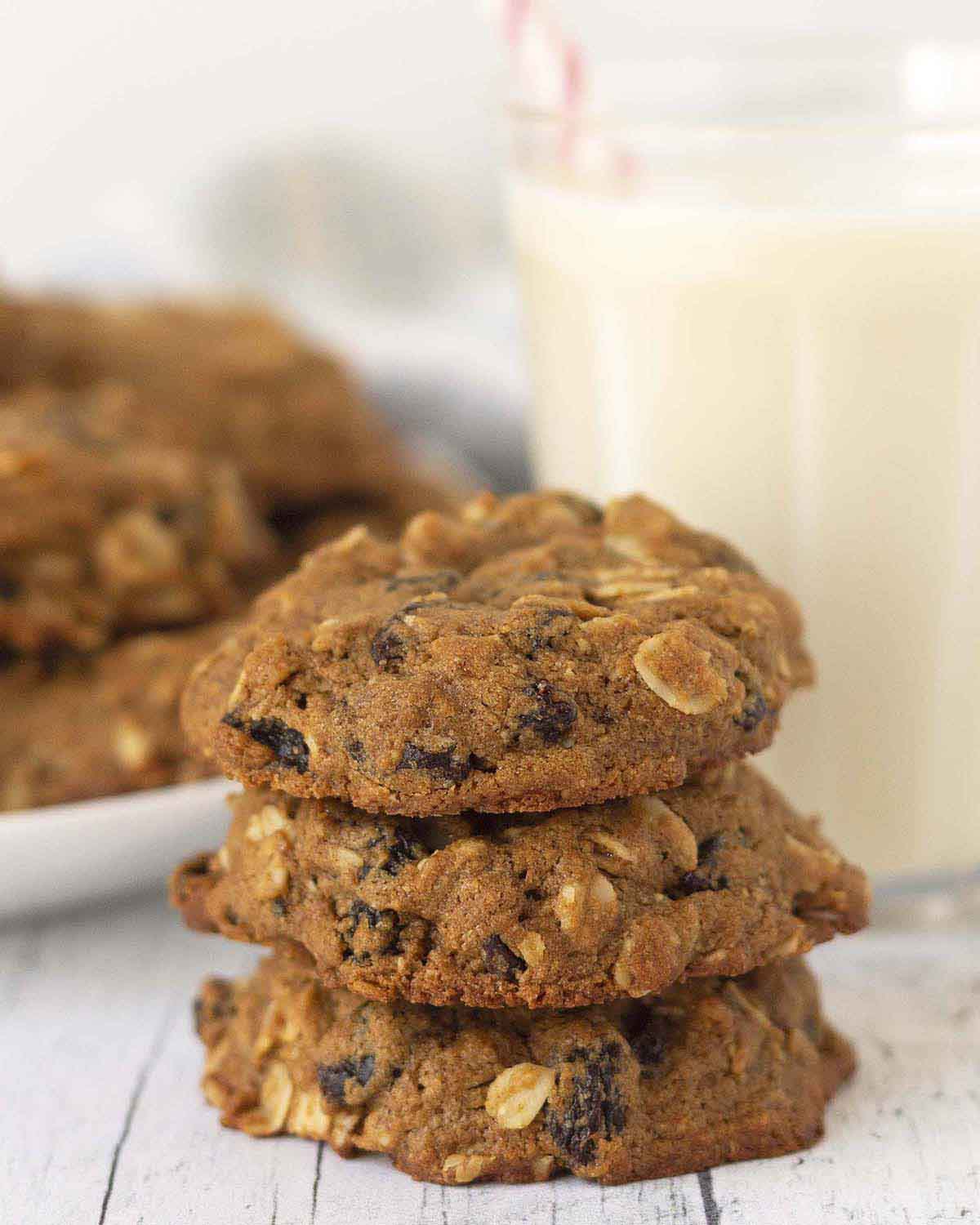 Image shows three oatmeal cookies with raisins stacked on top of each other.