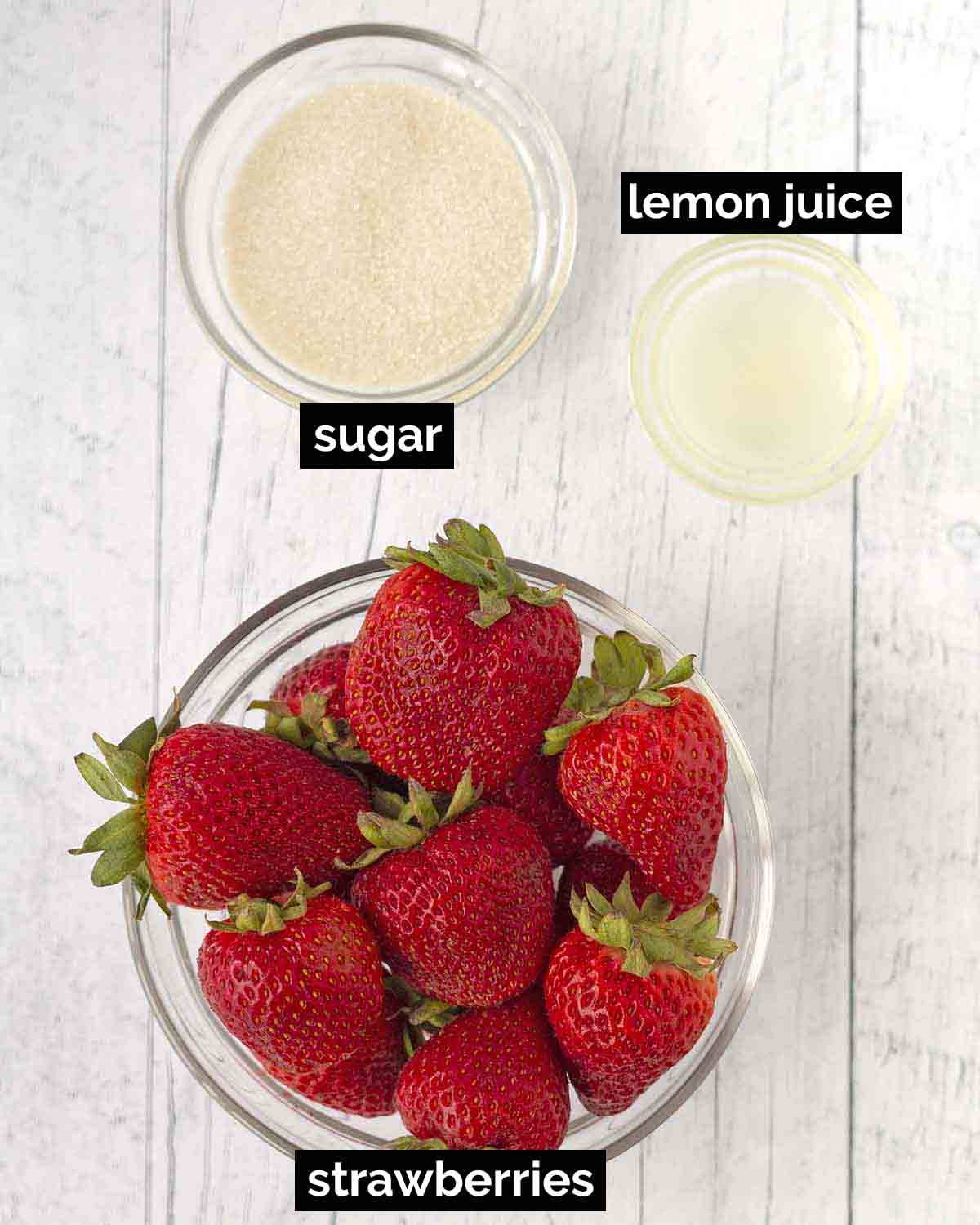 Image shows the three ingredients needed to make strawberry sauce with fresh strawberries (strawberries, sugar, lemon juice).