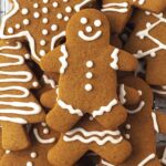 A stack of decorated gingerbread cookies, a gingerbread man is on top of the stack.