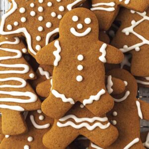 A stack of decorated gingerbread cookies, a gingerbread man is on top of the stack.