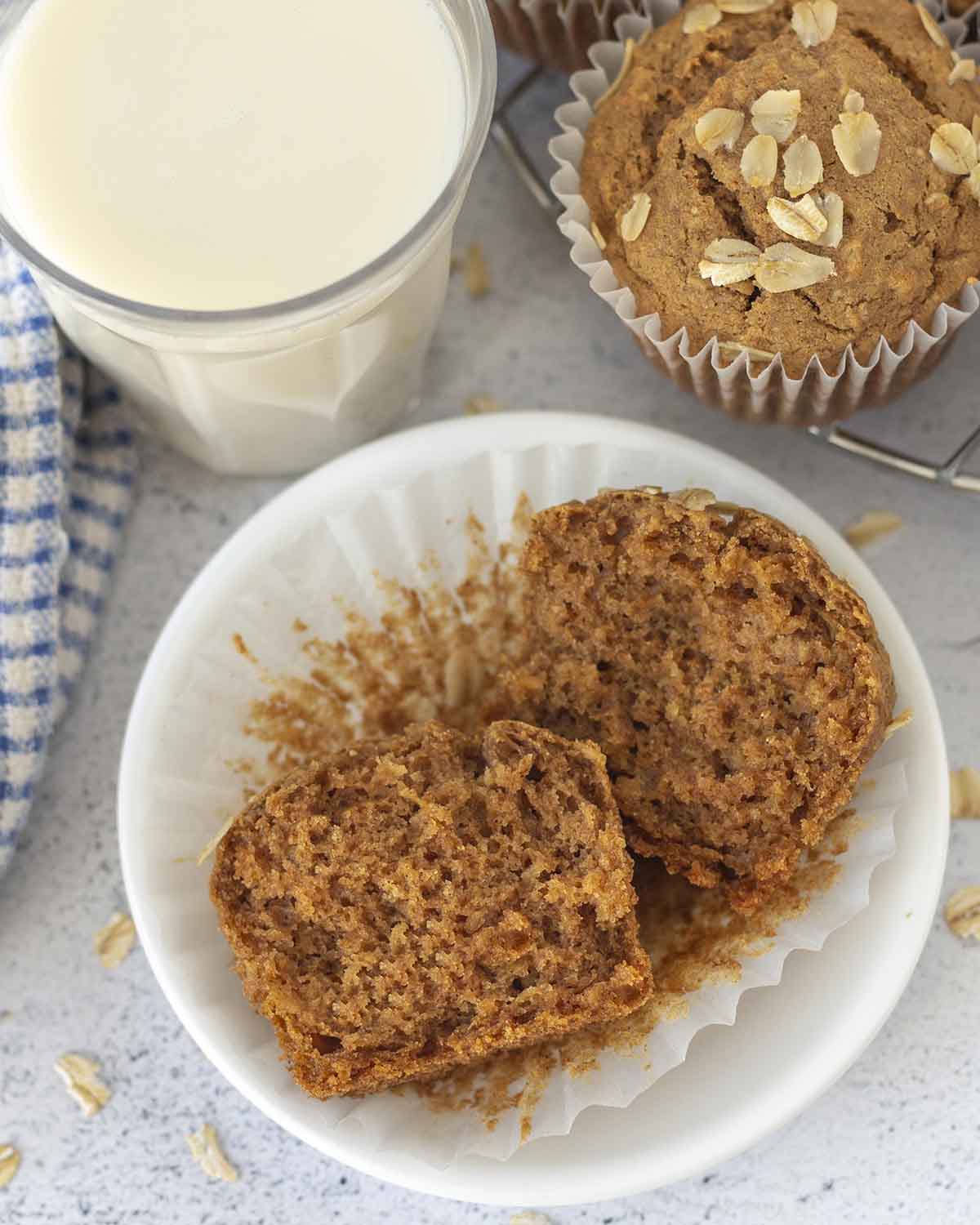 Image shows and overhead shot of an oatmeal muffin that has been split in half to show the inner fluffy texture.