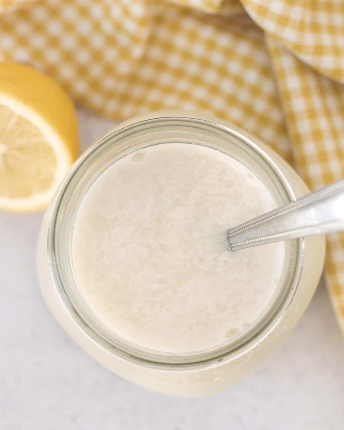 An overhead shot showing curdled vegan buttermilk in a jar.