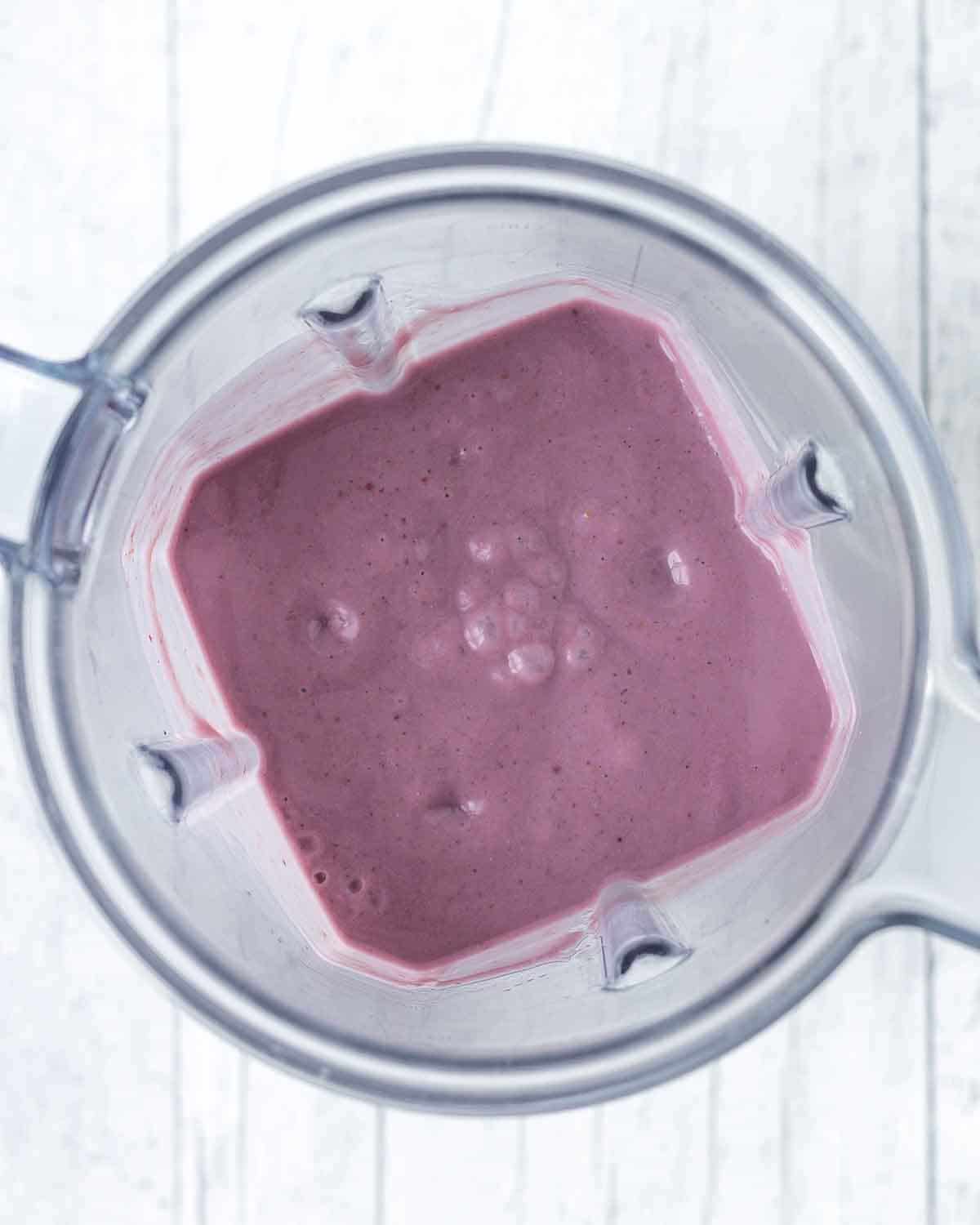 An overhead shot of freshly blended strawberry blackberry smoothie in a blender container.