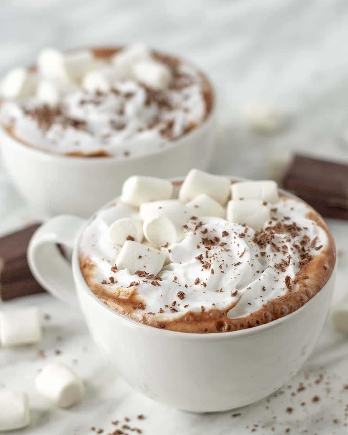 Oat milk hot cocoa in a small white cup with marshmallows on top.