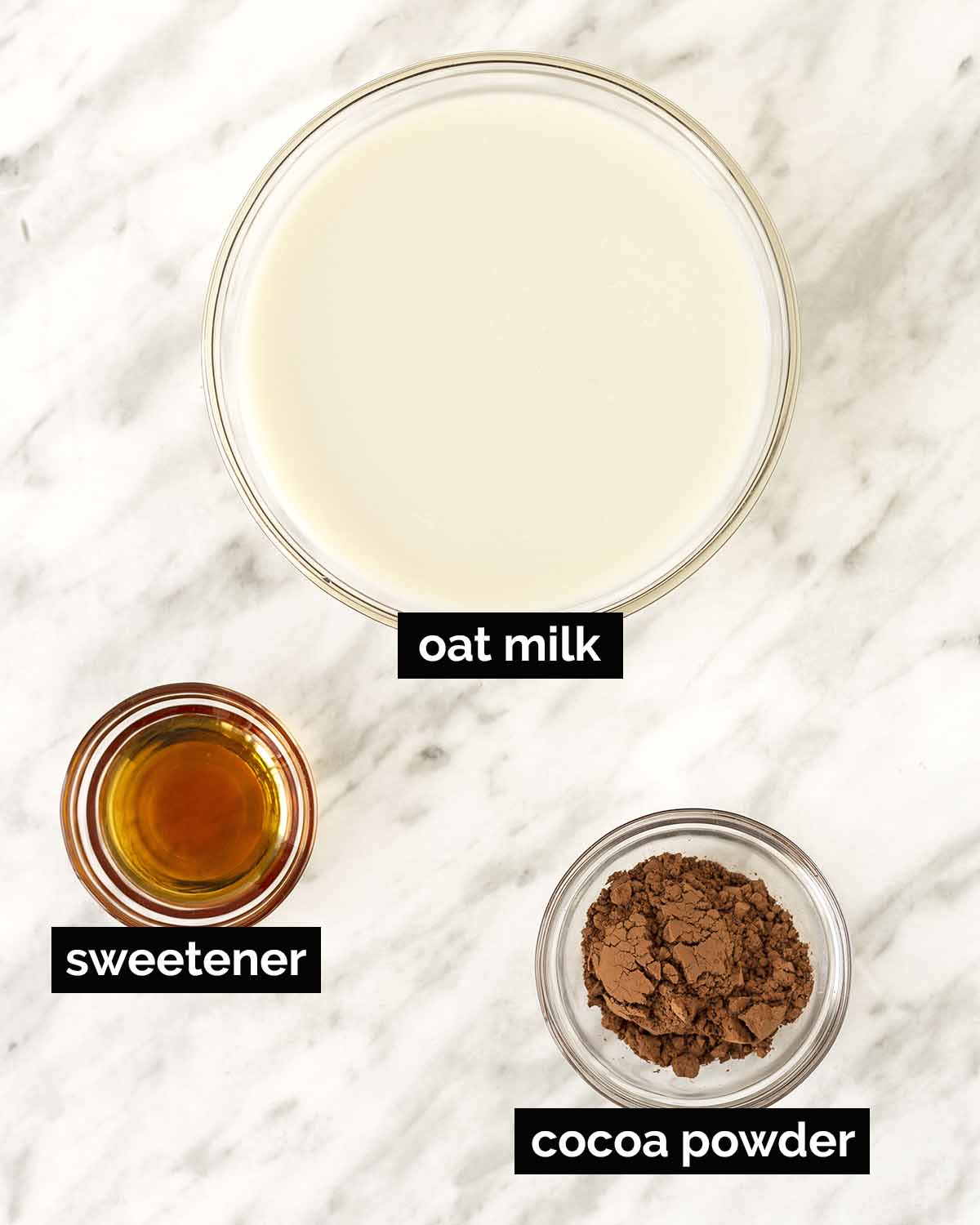 An overhead shot showing the ingredients needed to make hot chocolate with oat milk.