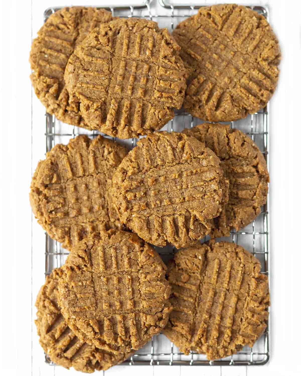 Overhead shot of almond flour peanut butter cookies stacked on a wire rack.
