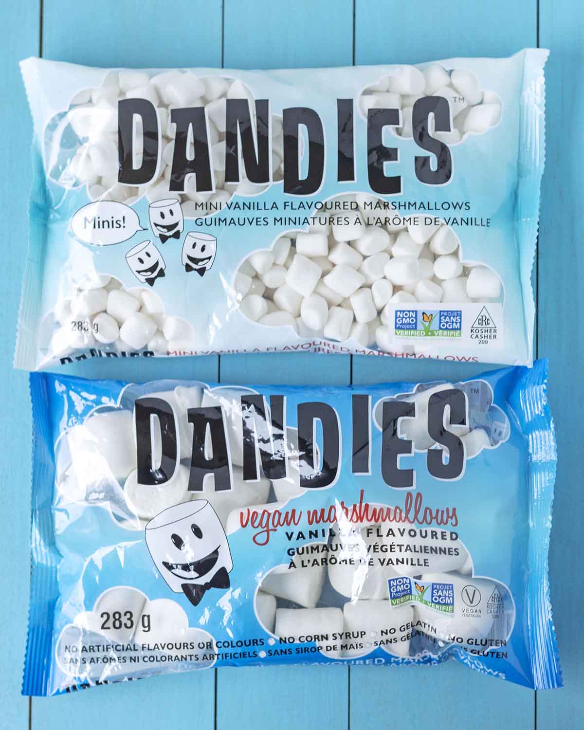 Overhead shot showing two bags of Dandies marshmallows on a blue table.