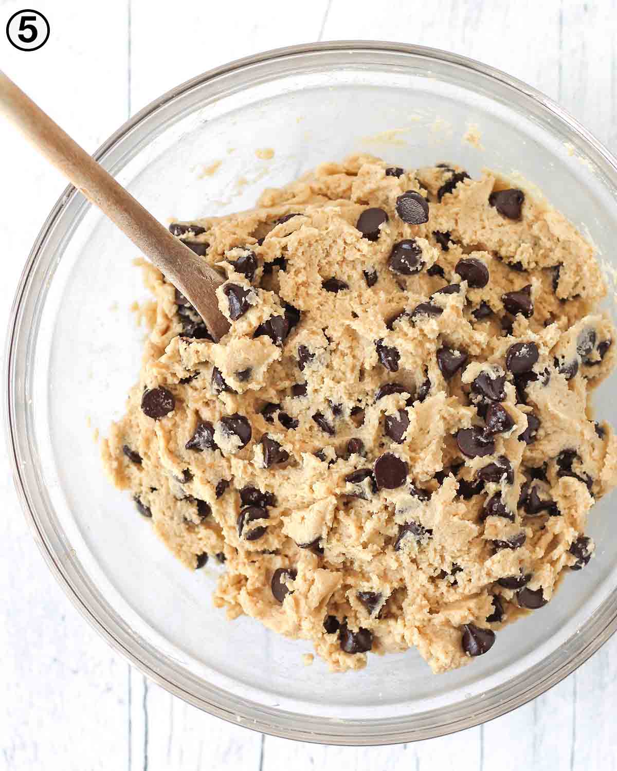 An overhead shot showing a glass bowl filled with vegan almond flour chocolate chip cookie dough.
