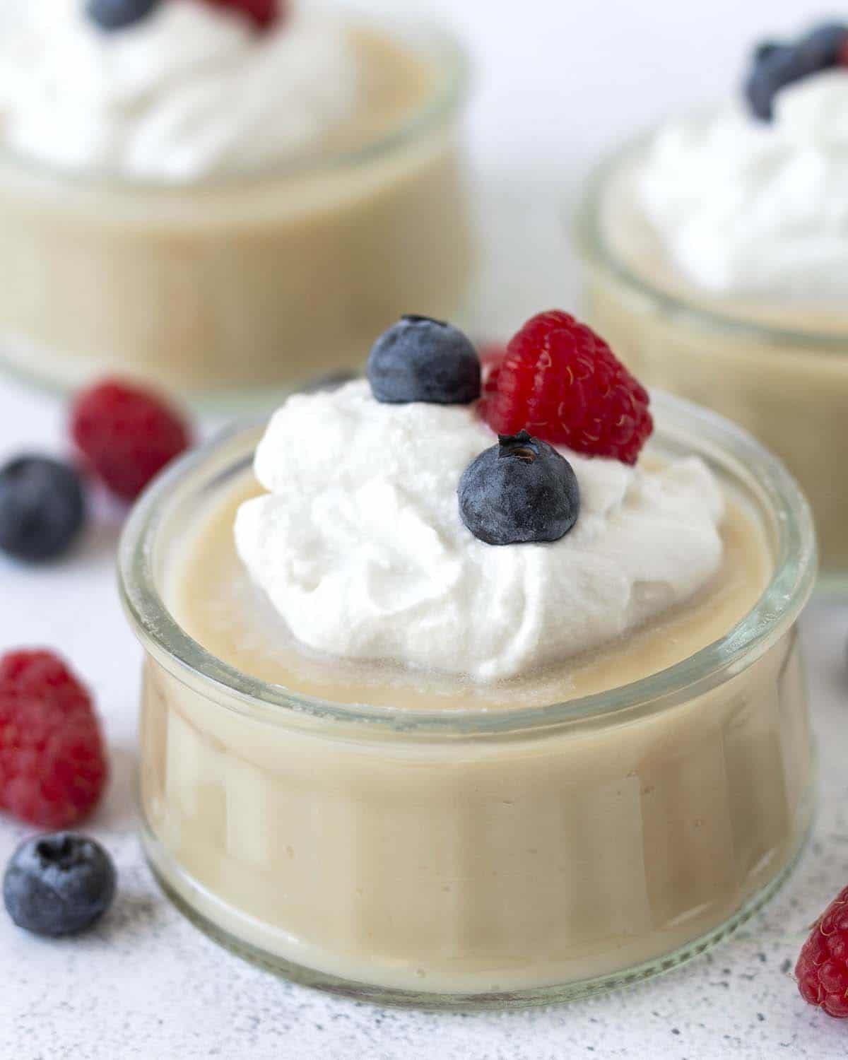 A close-up shot of egg-free vanilla pudding an a small glass bowl.