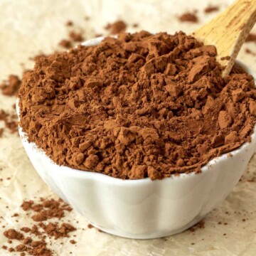 A close up shot showing cocoa powder in a white dish.