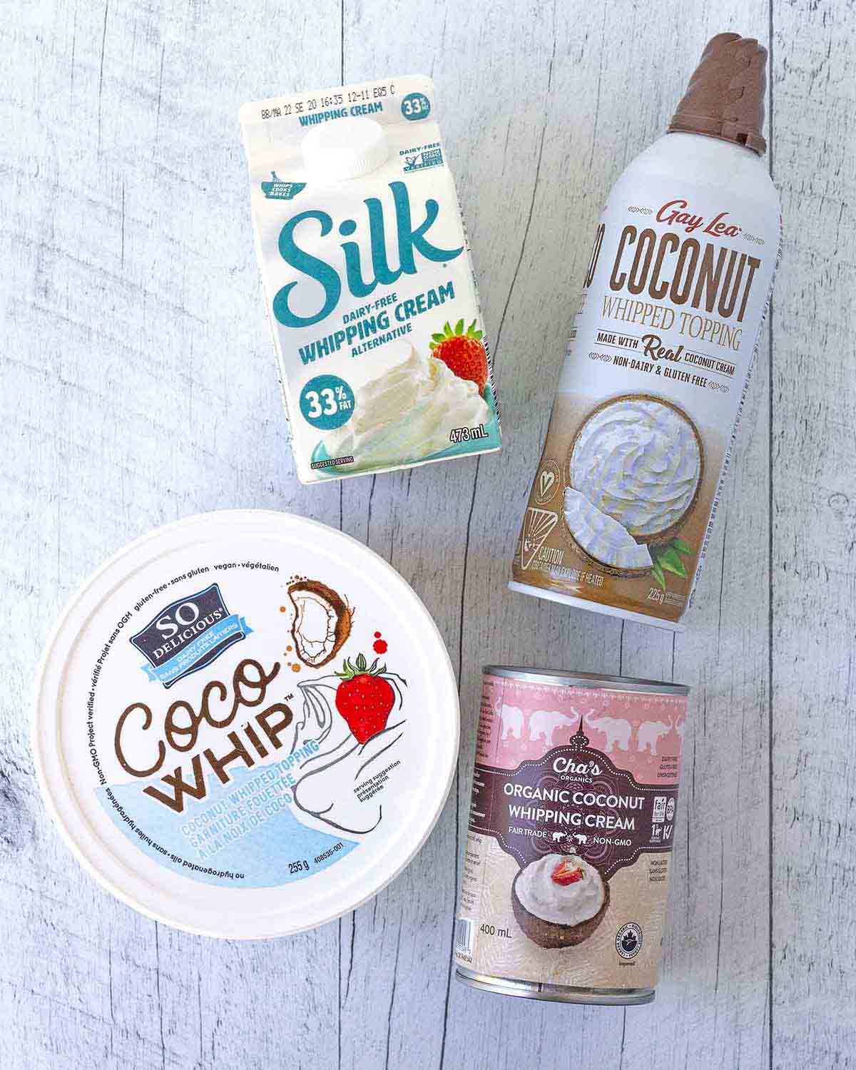 An overhead shot showing four brands of vegan whipped cream brands to look for at the store.