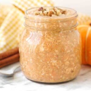 A close up shot of a mason jar of pumpkin spice overnight oats.