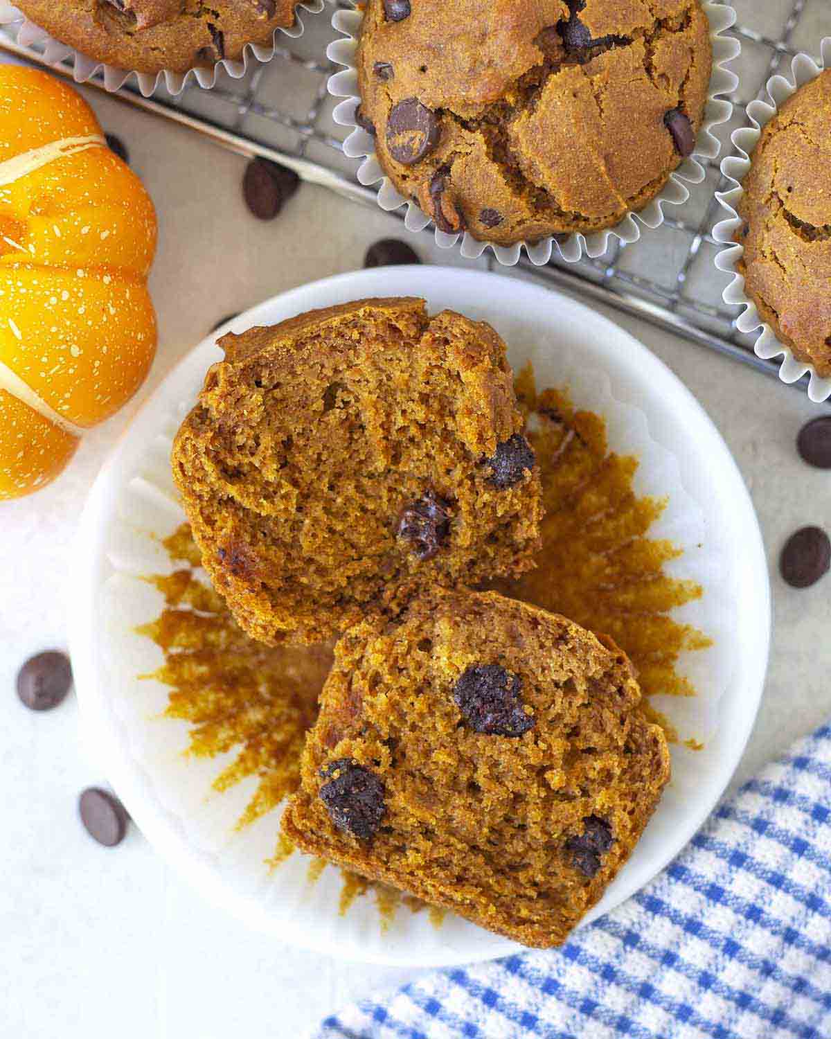 An overhead shot of a pumpkin chocolate chip muffin cut in half to show the fluffy inside.
