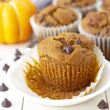 A gluten-free pumpkin muffin on a plate with its muffin wrapper peeled down.