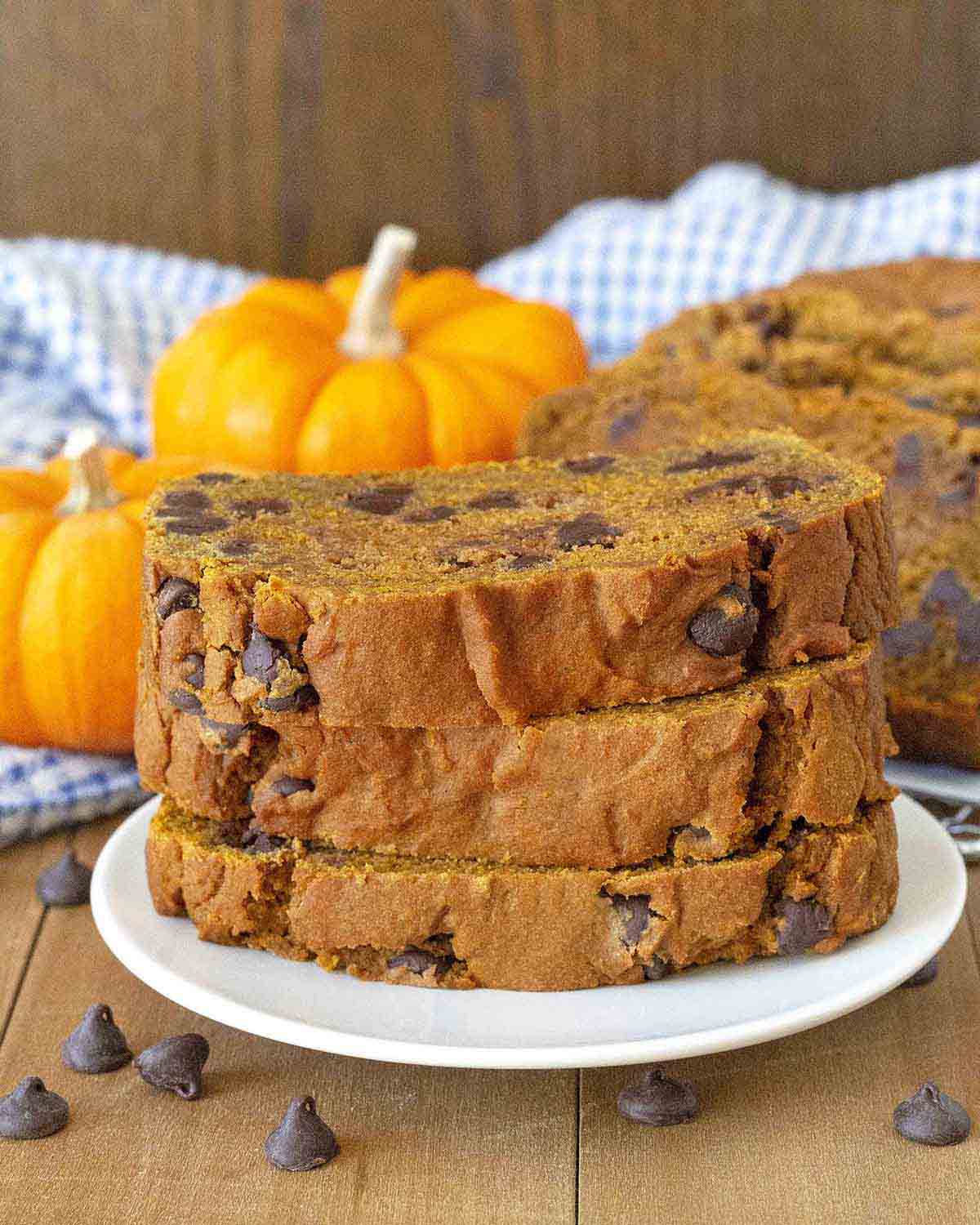 A stack of three vegan gluten free pumpkin bread slices on a plate.