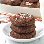Three vegan chocolate peppermint cookies stacked on top of each other, cookies are sitting on a small white plate.