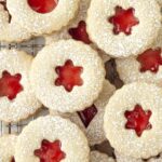 An overhead shot showing raspberry Linzer cookies sitting on a wire cooling rack.