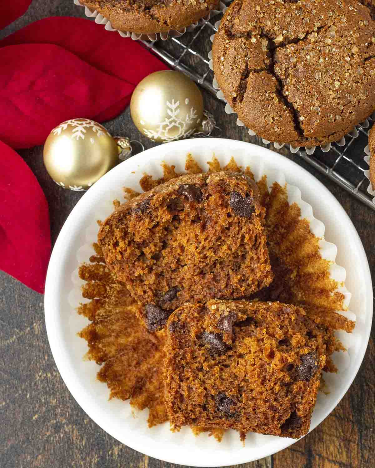An overhead shot of a gingerbread chocolate chip muffin cut in half to show the fluffy inside.