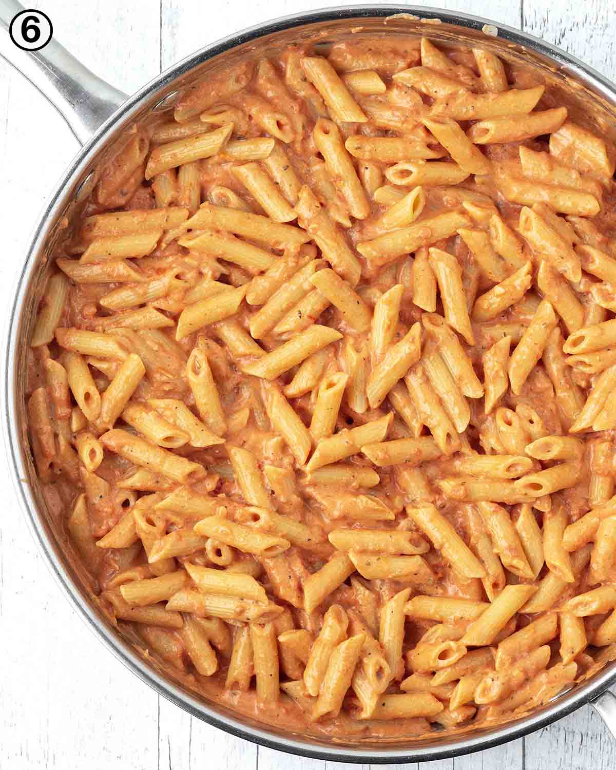 An overhead shot of creamy tomato pasta in a large pan.